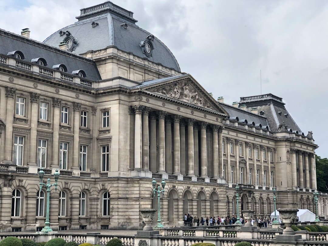 Historic event hall facade in Brussels with people gathering outside